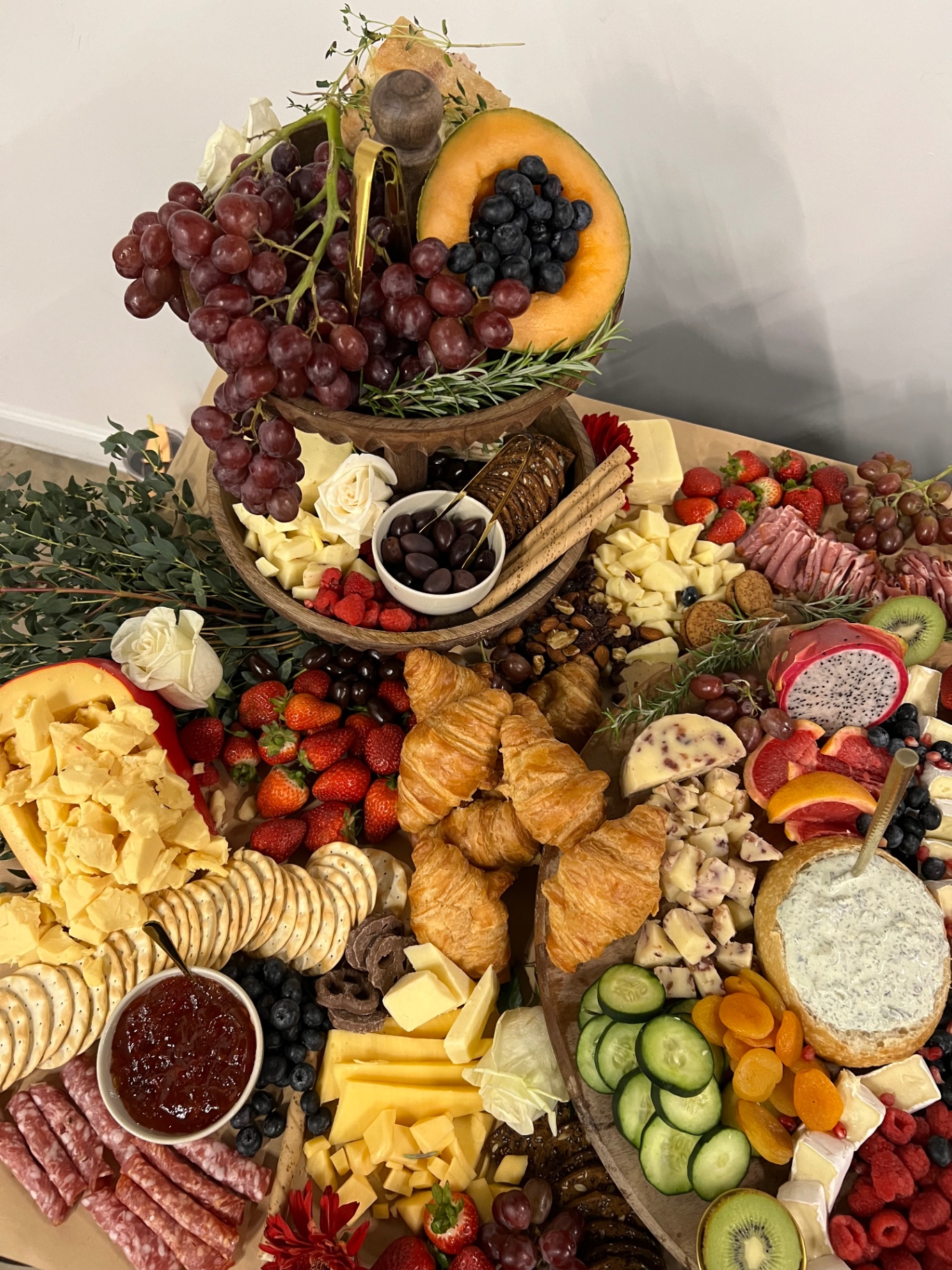 Tiered grazing display with cheeses, croissants and fresh berries