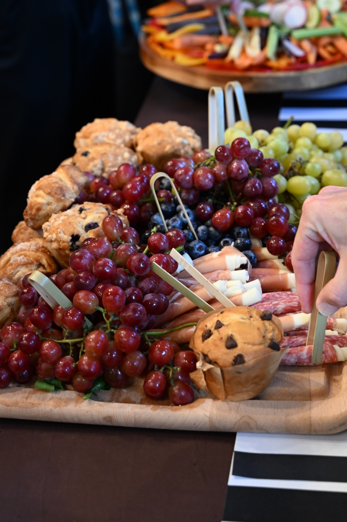 Board with croissants, scones, grapes, berries and charcuterie
